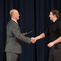 Doctor Potteiger shaking hands with an award recipeint in a black button down